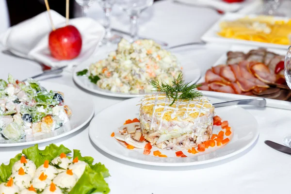 Cutting sausages and salads on a banquet table — Stock Photo, Image