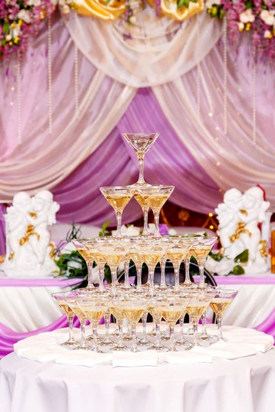 Pyramid of glasses with champagne in purple wedding interior. — Stock Photo, Image