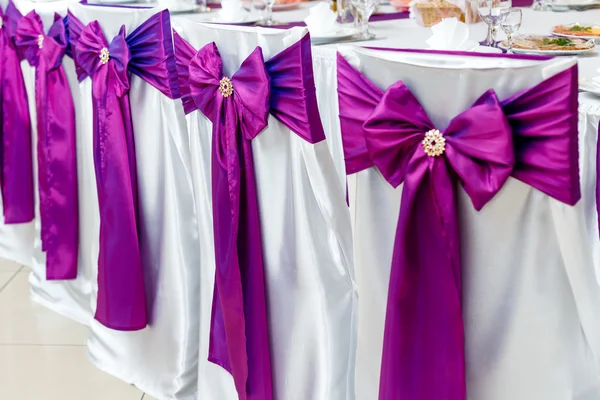 Chairs decorated with purple bows on ceremony — Stock Photo, Image