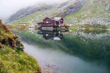 Romanya 'nın Fagaras dağlarından Balea gölü manzarası. Yeşil dağları olan Balea Gölü kulübesine bakın.