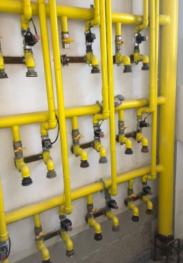 Vinci olan sarı gaz borusu, çok katlı yeni bir binanın ön cephesine gidiyor.