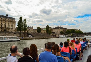 Seine nehrinde yelken açan insanlarla dolu bir tekne. Eyfel Kulesi, Fransa