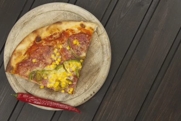 Pizza fatta in casa. Porzioni di pizza su un tavolo di legno scuro. Preparazione alimentare . — Foto Stock