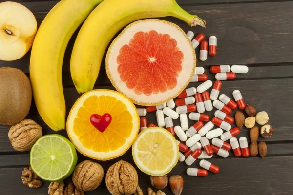 Gesunde Früchte für die Ernährung. frisches Obst auf dunklem Holzbrett. eine gesunde Ernährung mit Vitaminen. künstliche Sport-Nahrungsergänzungsmittel. — Stockfoto