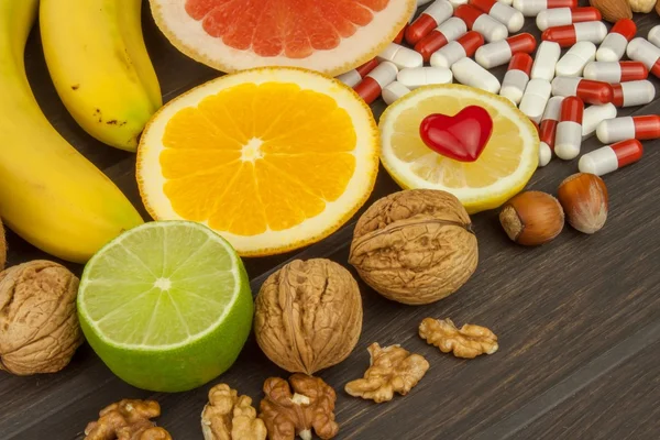 Frutta sana per la dieta. Frutta fresca su tavoletta di legno scuro. Una dieta sana con vitamine. Integratori artificiali di nutrizione sportiva . — Foto Stock