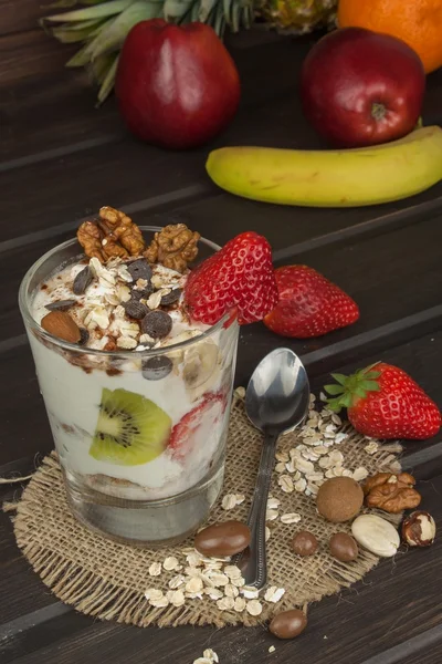 Voorbereiding gezond ontbijt voor kinderen. Yoghurt met havermout, fruit, noten en chocolade. Havermout voor het ontbijt. Dieet maaltijden bereiden. Een gezonde voeding voor atleten. — Stockfoto