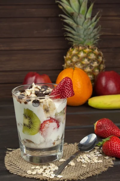 Préparation d'un petit déjeuner sain pour les enfants. Yaourt à la farine d'avoine, fruits, noix et chocolat. Farine d'avoine pour le petit déjeuner. Préparation des repas diététiques. Une alimentation saine pour les athlètes . — Photo