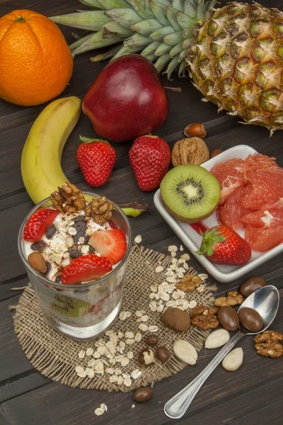 Förbereda hälsosamma frukost för barn. Yoghurt med havregryn, frukt, nötter och choklad. Havregrynsgröt till frukost. Laga diet mat. En hälsosam kost för idrottare. — Stockfoto