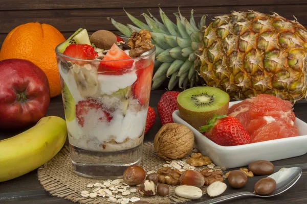 Preparación de un desayuno saludable para los niños. Yogur con avena, fruta, nueces y chocolate. Avena para el desayuno. Preparación de comidas dietéticas. Una dieta saludable para los atletas . —  Fotos de Stock