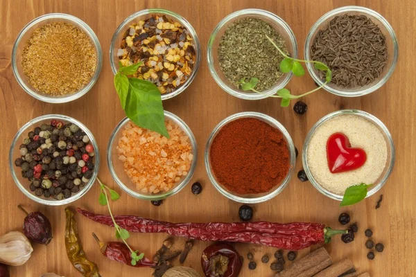 A alegria de cozinhar, preparação de especiarias. Vários tipos de temperos em uma tábua de madeira. Preparação de alimentos. Especiarias na mesa da cozinha . — Fotografia de Stock