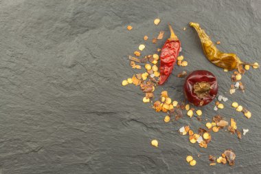 Kurutulmuş biber koyu slate üzerinde. Güçlü baharatlar baharatlı gıdalar için. Mutfak süsleyin. Metin için yer. Menü oluşturma.