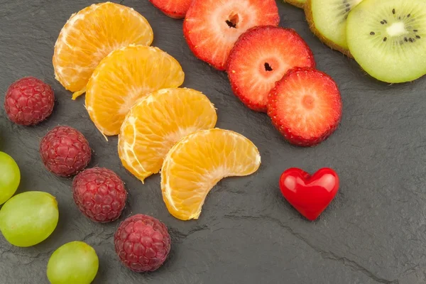Hallon, jordgubb, tangerine, vindruvor och kiwi på skiffer bakgrund. Hälsosam mat på köksbordet. Förbereda menyn. — Stockfoto