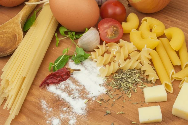 Homework pasta foods. Ingredients for cooking, spread out on the kitchen table. Traditional Italian food. Diet food. — Stockfoto