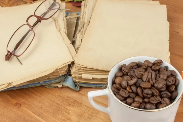 Livro antigo e uma chávena de café na mesa. Ler livros antigos . — Fotografia de Stock