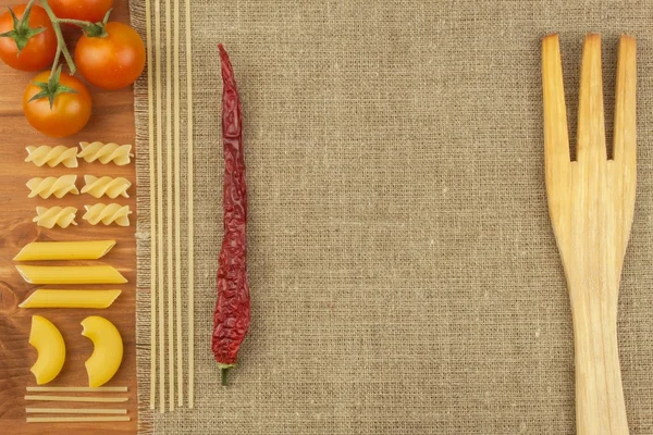 Decoração de massa. A preparar comida caseira. Diferentes tipos de massas no fundo de madeira. A criar o menu. Lugar para o seu texto . — Fotografia de Stock