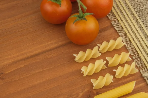 Decoración de pasta. Preparando comida casera. Diferentes tipos de pasta en el fondo de madera. Crear el menú. Lugar para su texto . — Foto de Stock