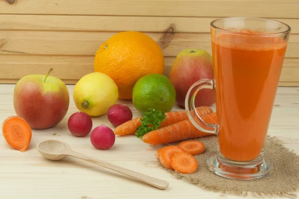 Glass of carrot juice and carrots on the wooden table. Healthy juice full of vitamins and fiber. Diet Food. Carrot segments on a wooden background. — Stock Photo, Image