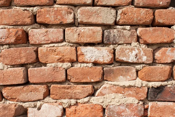 Il vecchio muro di mattoni che si sbriciola. Mattoni e pietre nel vecchio muro. Il vecchio muro di mattoni crolla e la riparazione urgente è necessaria — Foto Stock