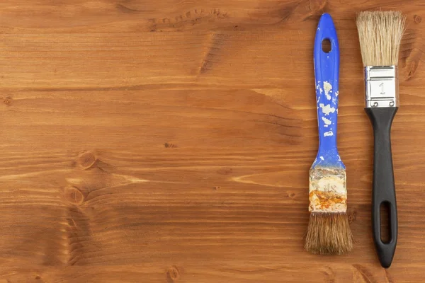 Kwast op houten achtergrond. Verkoop van verf en penselen. Huishoudelijk werk. Supplies voor schilders. — Stockfoto