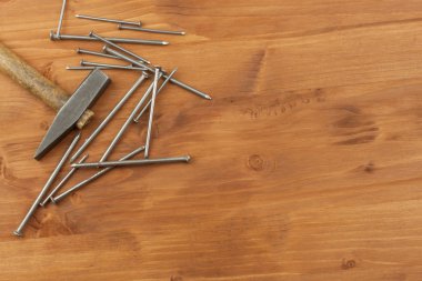 Eski çekiç ve çivi, irili ufaklı kazık. Vintage eski paslı çivi çekiç. Ahşap arka plan üzerinde araçları.