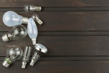 Ahşap bir arka plan üzerinde akkor ampuller farklı türleri ve şekilleri. Ampul satışı. Aydınlatma ekipmanları için reklam.