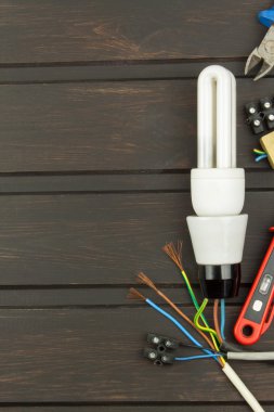 Repair broken lights. Energy saving light bulb on a dark background. Sales of light bulbs. Advertising on lighting technology. Eletro desk technician.