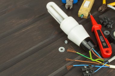 Repair broken lights. Energy saving light bulb on a dark background. Sales of light bulbs. Advertising on lighting technology. Eletro desk technician.