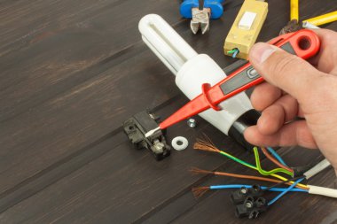 Repair broken lights. Energy saving light bulb on a dark background. Sales of light bulbs. Advertising on lighting technology. Eletro desk technician.