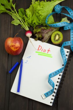 Diyet programı için hazırlanıyor. Diyet başlatmak için karar. Diyet planlama. Defter ölçüm bantları ve kalem ahşap tablo.