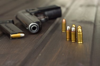 Tabanca Mühimmat üzerinde koyu ahşap bir masa ile. Silah ve mühimmat satışı. Cephane reklam. Yeni silah ve mühimmat. Bakkal mühimmat. Savunma için mühimmat kaynağı.