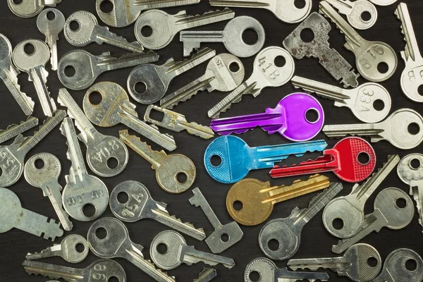 Silver Keys and color on dark wooden board. Different types of keys. — Stock Photo, Image