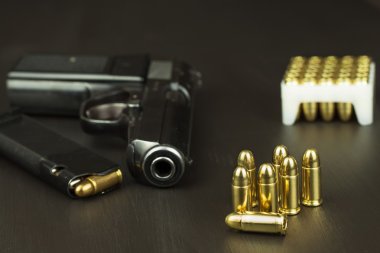 Tabanca Mühimmat üzerinde koyu ahşap bir masa ile. Silah ve mühimmat satışı. Cephane reklam. Yeni silah ve mühimmat. Bakkal mühimmat. Savunma için mühimmat kaynağı.