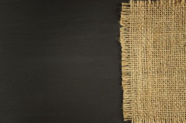 Siyah ahşap tahta üzerinde eski çuval bezi