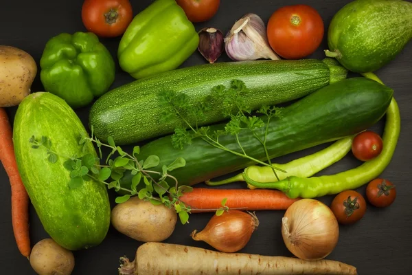 Különféle zöldségek egy régi fából készült asztal. Friss zöldségfélék értékesítése. A sportolók táplálék-kiegészítők. — Stock Fotó