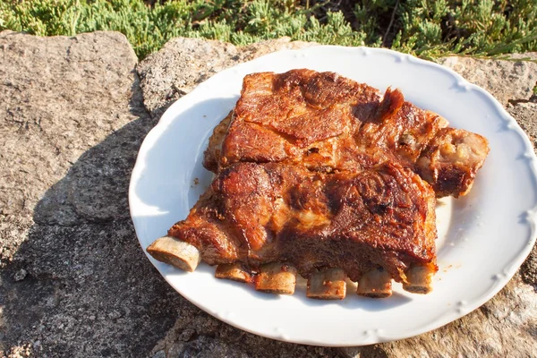 Costillas de cerdo a la parrilla. Costillas asadas marinadas en una fiesta de verano. Noche en una fiesta . —  Fotos de Stock