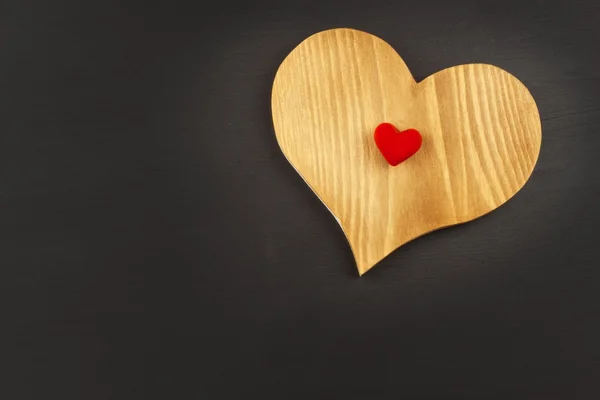 Corazón de madera sobre un fondo oscuro. Tarjetas de San Valentín . — Foto de Stock