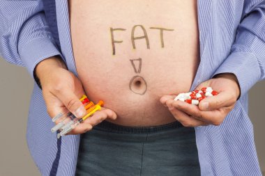 Obezite tedavisinde. Evde kendi kendine insülin enjeksiyon yapma şırınga ile şişman adam. Obezite sa˜l'k. Şeker hastalığı tedavisi.