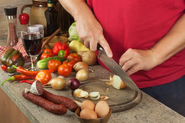 Chef a tranché l'oignon à bord. Préparation de légumes pour une salade saine. Trancher les oignons et les tomates. Légumes frais dans la cuisine . — Photo