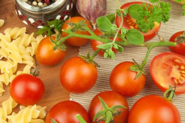 Tahta bir arka plan üzerinde domates ve maydanoz ile çiğ makarna. Hazırlık diyet gıda. Basit bir akşam yemeği için tarifi. Sebzeli geleneksel makarna.