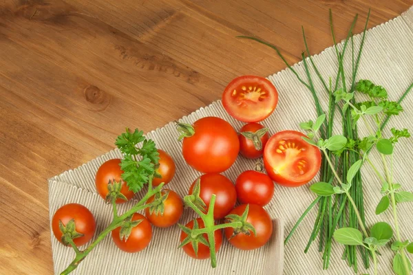 Čerstvá třešňová rajčata na rustikálním dřevěném podkladu. Čerstvá zelenina na kuchyňském stole. Příprava potravinových doplňků. — Stock fotografie
