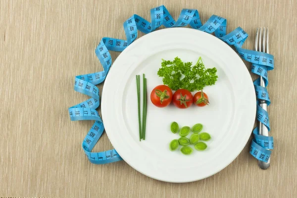 Строга дієта проти ожиріння. Дієтична овочева дієта. Помідори на тарілці. Сирі овочі на білій тарілці та вимірювальна стрічка . — стокове фото