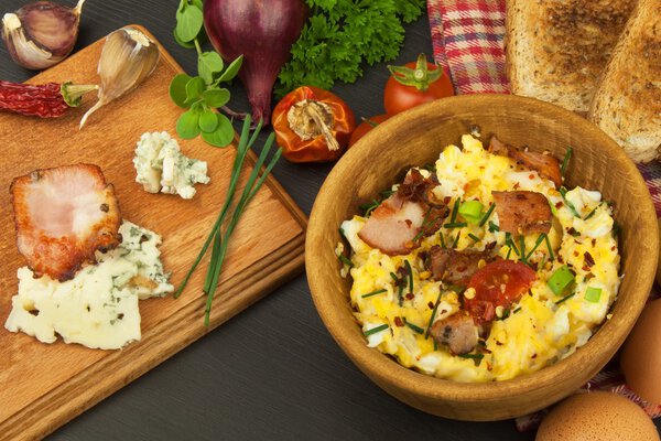 Scrambled eggs with fried bacon. English breakfast. Toast and scrambled eggs with chives. Recipe for a healthy meal.