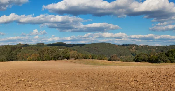 Freshly plowed field. Panorama of agricultural landscape. Autumn in agriculture. Blue sky and brown field. — Stock Photo, Image