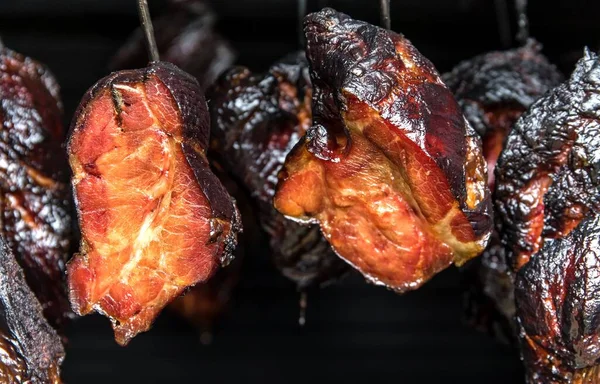 Smoking meat in the smokehouse. Traditional method of smoking meat in smoke. Food without chemicals and preservatives.