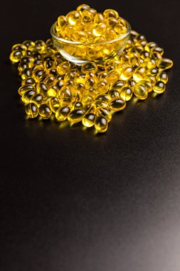 Siyah arka planda morina yağı Omega 3 jel kapsülleri. Sağlıklı beslenme için D vitamini ve Omega 3 hapları. Grip önleme.