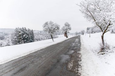 Çek Cumhuriyeti, Avrupa 'da kış yolu ve ağaçlarla kaplı. Taze yağmış kar ve kırsal kesimde sürülmüş yol. Kaygan yol.
