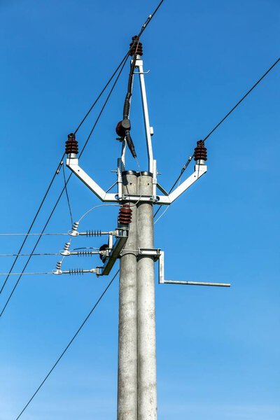 High-voltage electrical insulator electric line against the blue sky. Energy Electricity Power Pylon on a Blue Sky.  Electricity distribution in the Czech countryside.