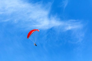 Paramotor mavi gökyüzünde uçuyor. Maceracı Ekstrem Spor Pilotu Paraşüt motorlu paraşütle gökyüzünde uçuyor