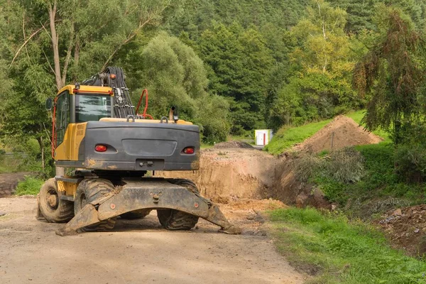 Repair of a road bridge in the Czech Republic near the village of Rikonin. Excavator on an empty construction site. Road repair.