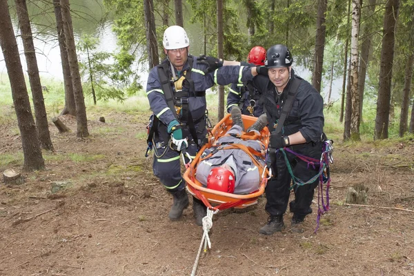 Pnovany, Repubblica Ceca, 4 giugno 2014: addestramento per soccorrere le persone ferite in terreni difficili presso la diga, portando con sé una barella con un ferito — Foto Stock